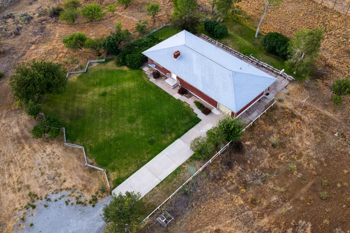 Ranch-style residence featuring a metal roof and a long concrete driveway