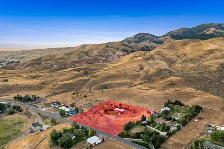 Expansive property with a single-story residence and a detached structure, situated on a gently sloping parcel
