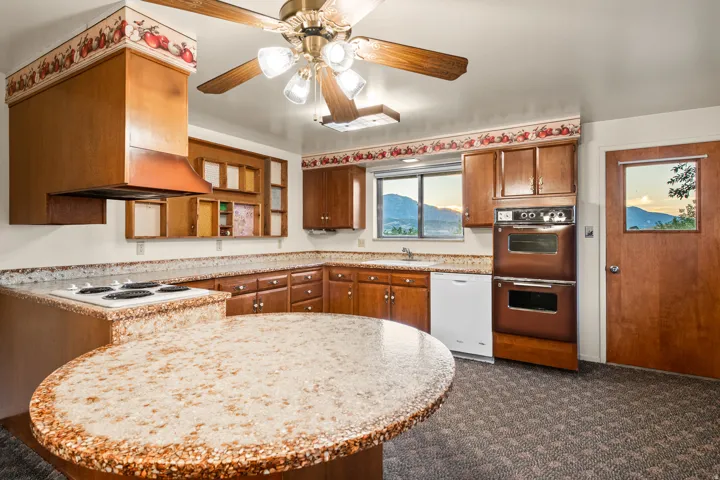 Kitchen featuring wood cabinetry, a built-in double oven, and a cooktop