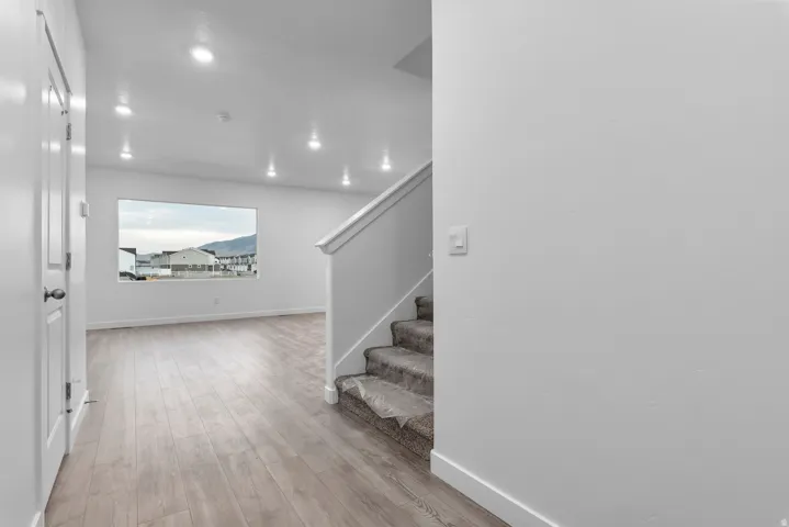 Open-concept living space featuring wood-finish flooring, recessed lighting, and a large picture window