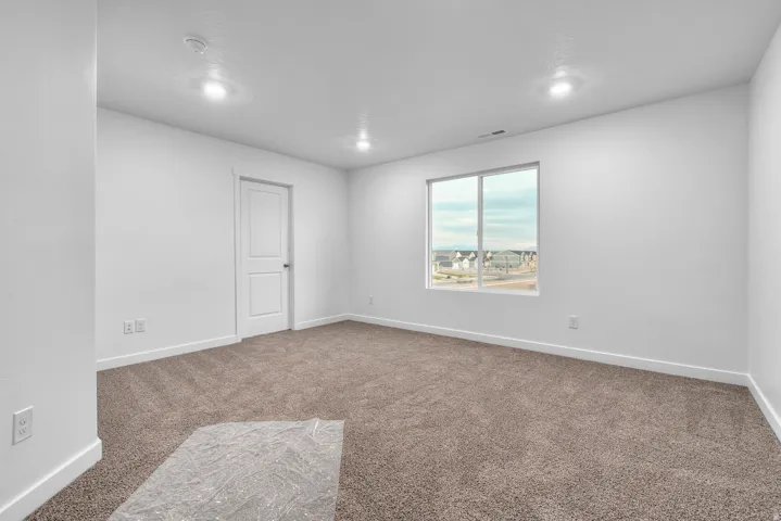 Neutral-toned carpeting complements the bright white walls and trim