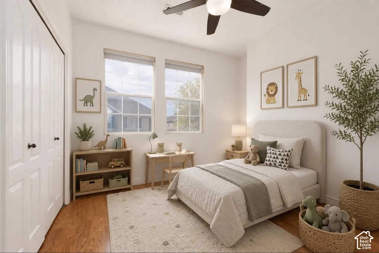 Light-filled interior featuring wood-finish flooring, a ceiling fan with integrated lighting, and two double-hung windows