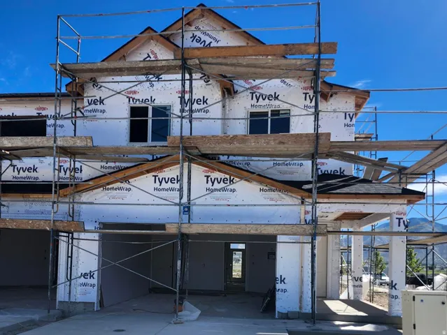 Two-story exterior with a multi-gabled roofline, multiple window openings, and a concrete driveway