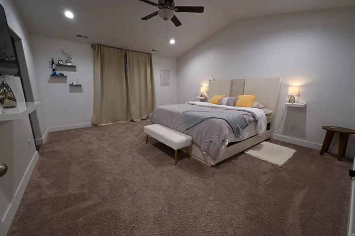Spacious room featuring vaulted ceilings, recessed lighting, and a ceiling fan