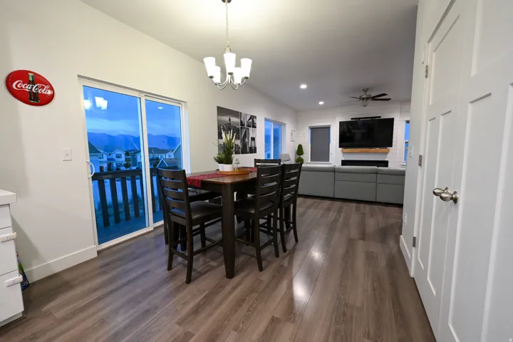 Open-concept living space featuring wood-finish flooring, recessed lighting, and a modern chandelier