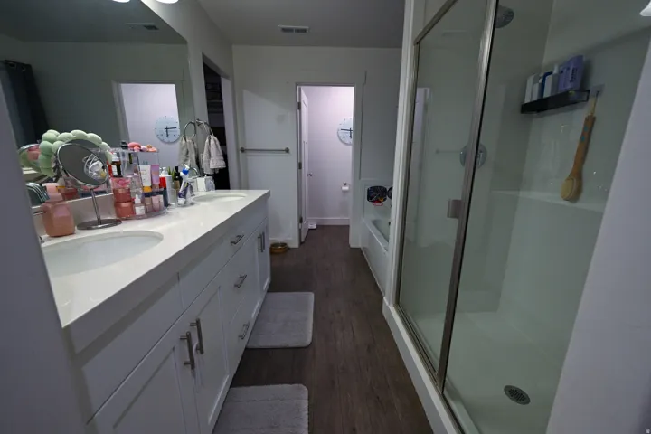 Bathroom featuring a double vanity with white cabinetry, dual undermount sinks, and a light-colored countertop
