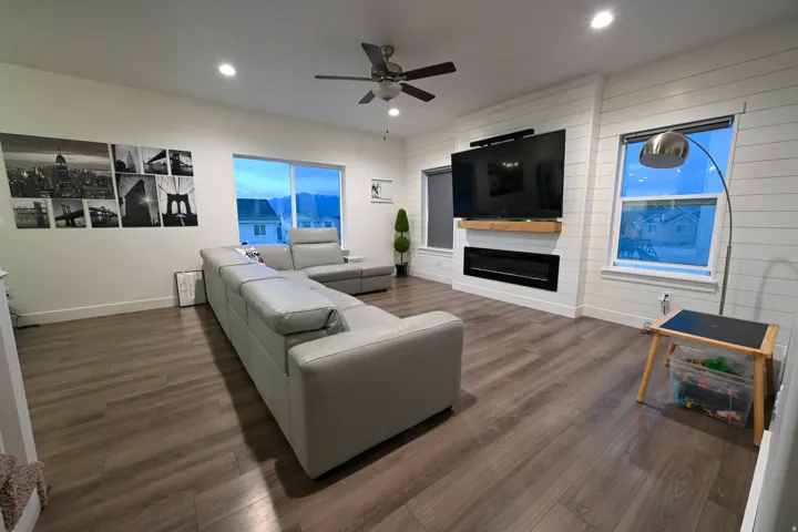 Open-concept living area featuring wood-finish flooring, recessed lighting, and a ceiling fan