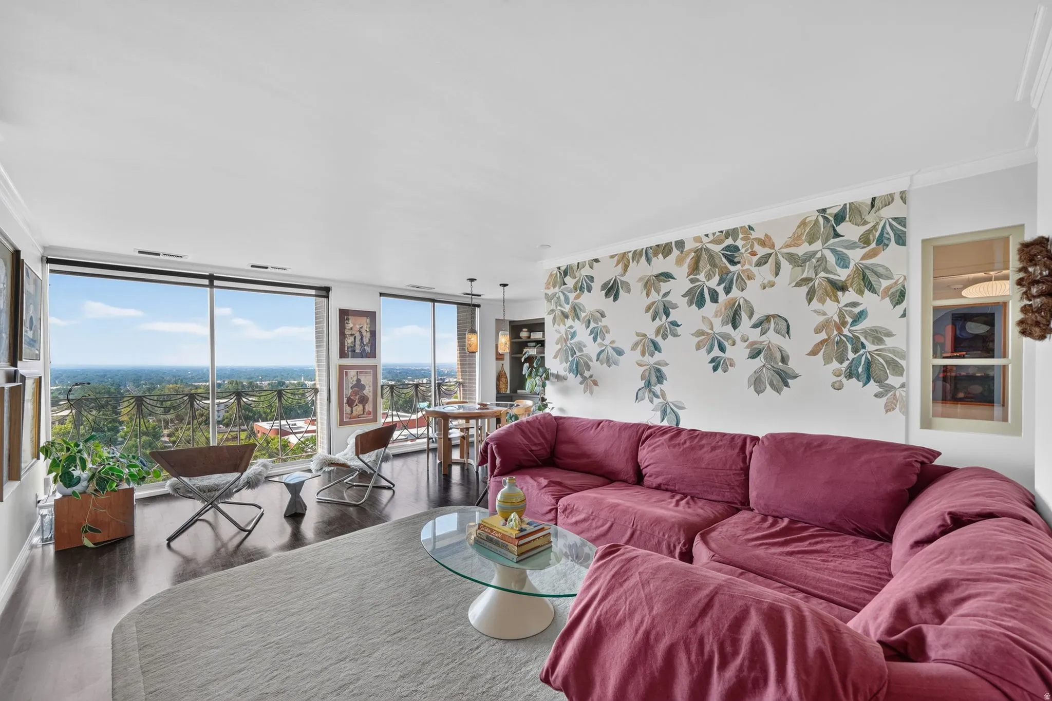 Living area with dark wood-finish flooring and expansive floor-to-ceiling windows