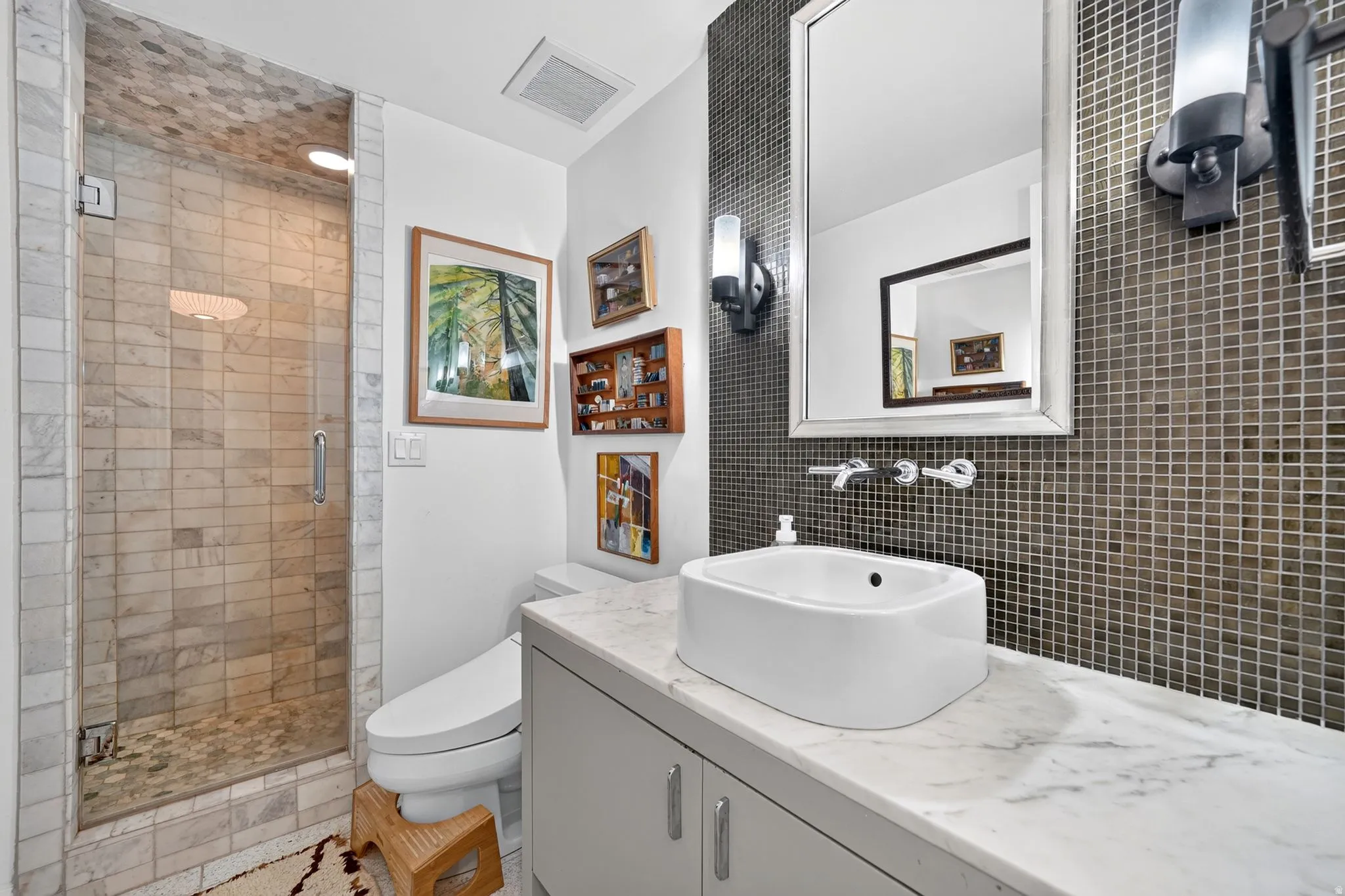 Contemporary bathroom with a glass-enclosed shower featuring subway tile and a pebble floor