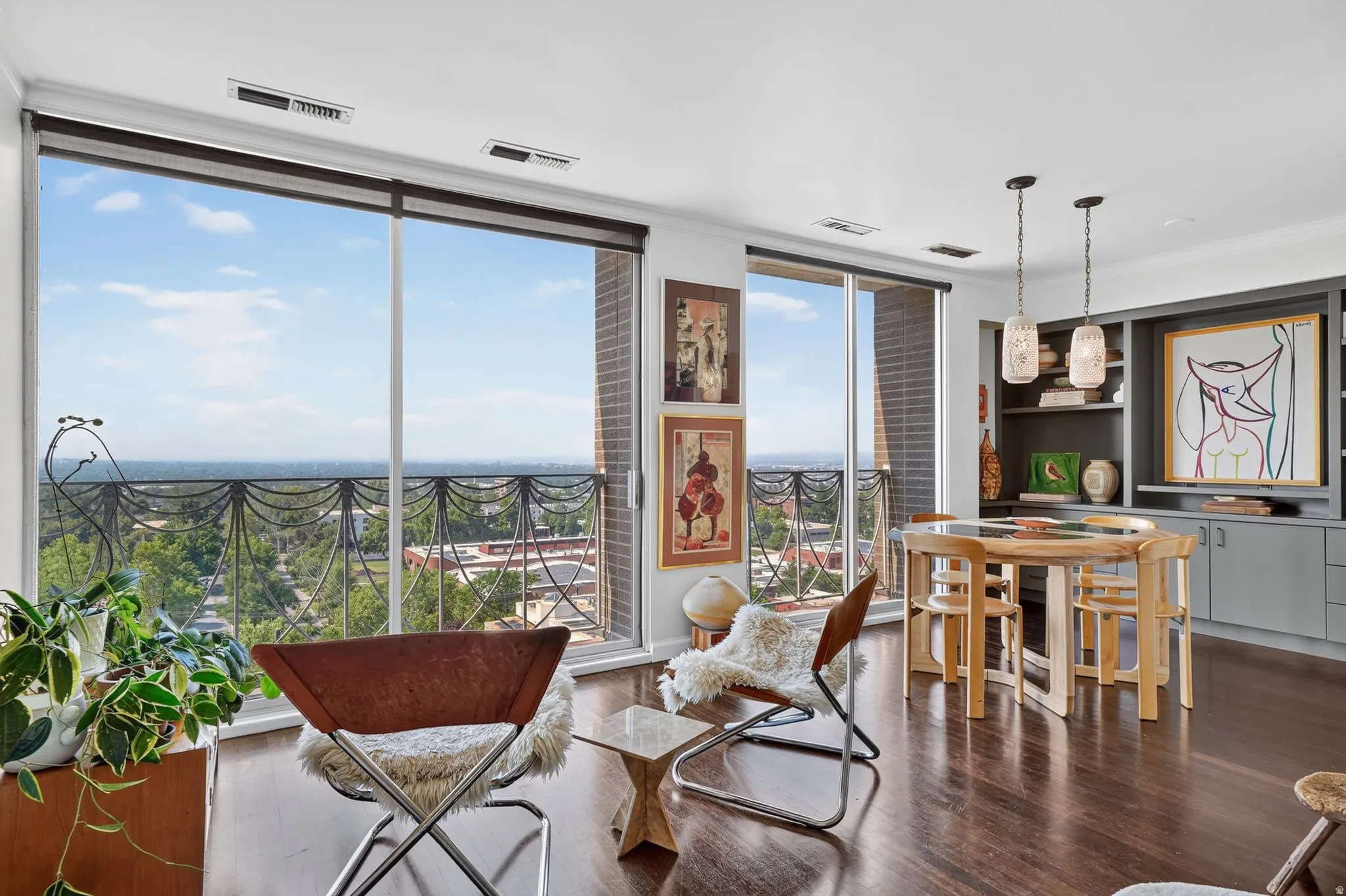 Expansive wall of windows with a metal balcony railing offering elevated vistas