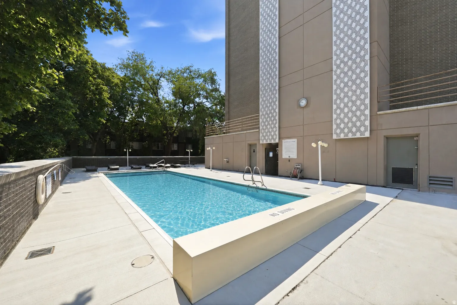 Rectangular swimming pool surrounded by a light-colored concrete deck