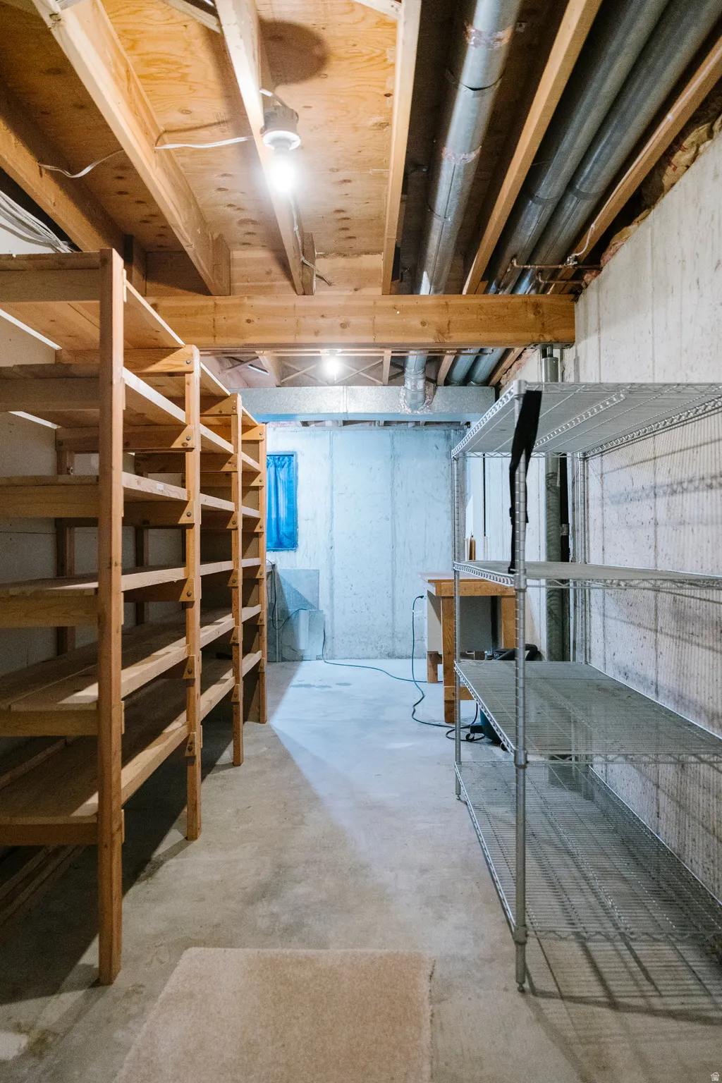 Unfinished basement with concrete flooring and exposed ceiling joists