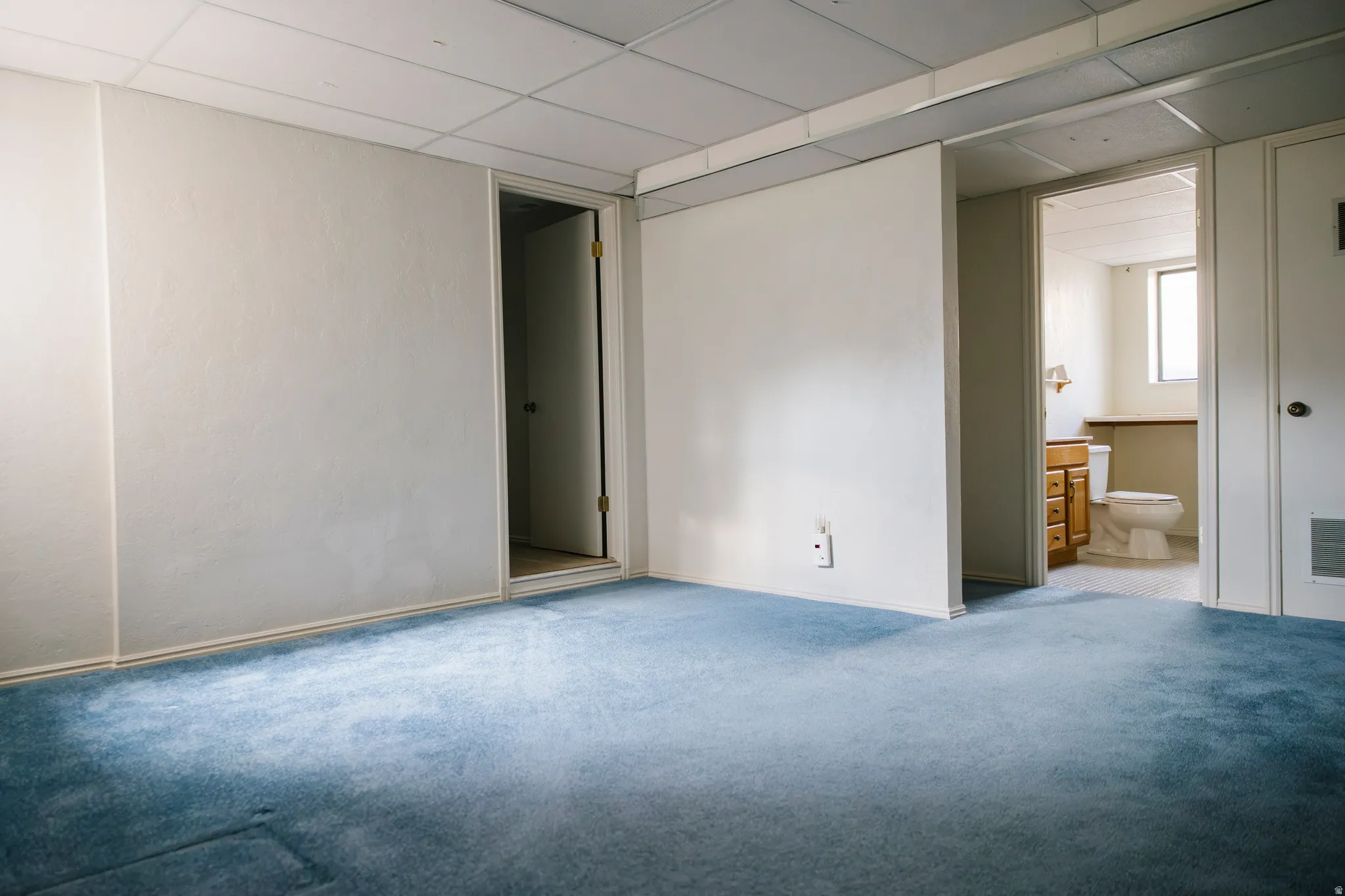 Spacious interior with blue carpeting and white walls