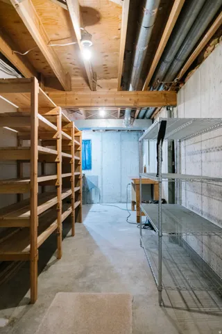 Unfinished basement with concrete flooring and exposed ceiling joists
