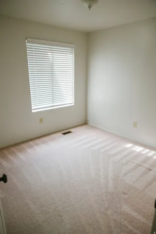Neutral-toned walls complement the light-colored carpeting