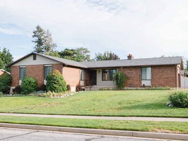 Brick and siding exterior residence featuring a front lawn and established landscaping