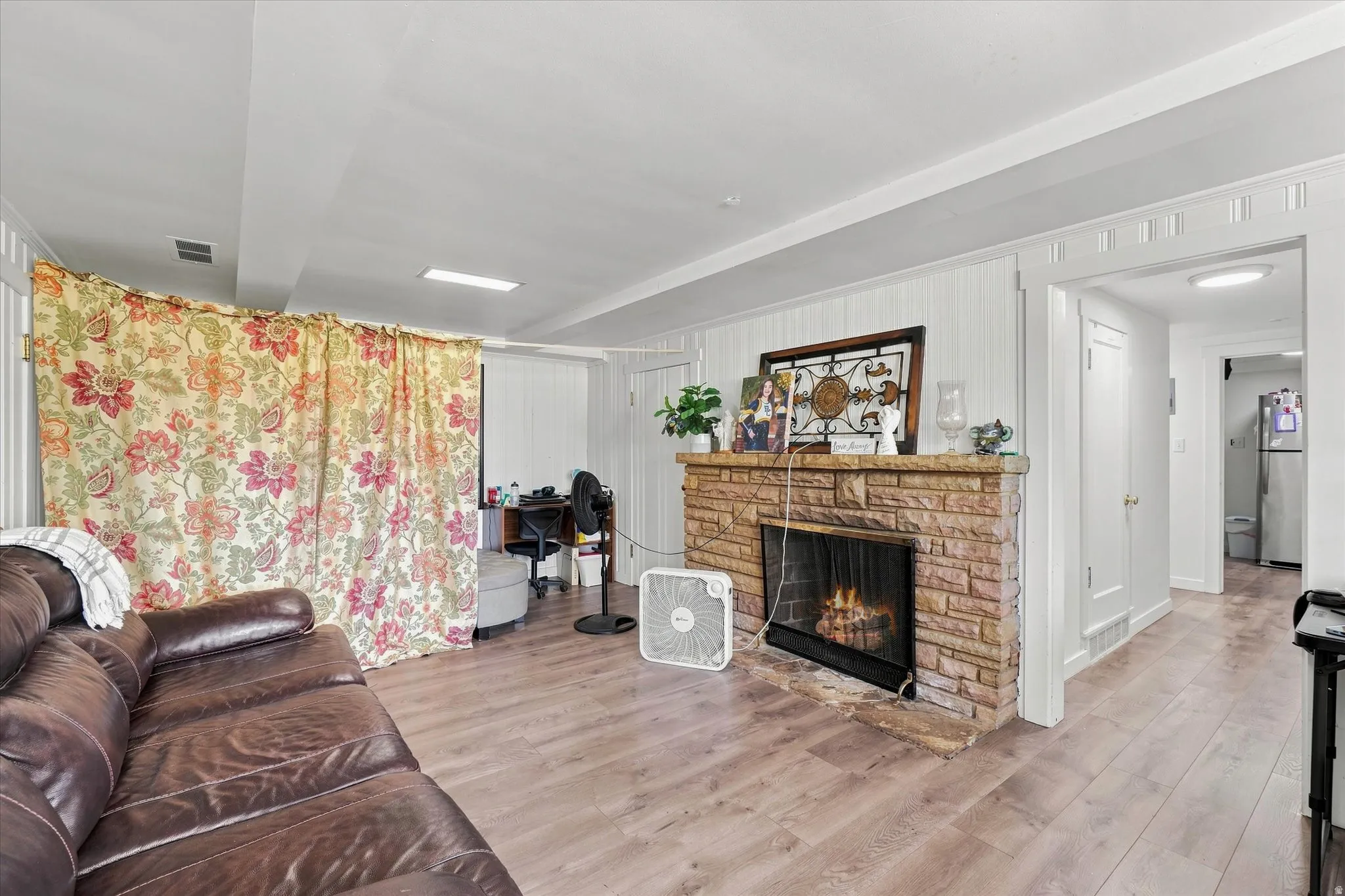 Wood-finish flooring throughout, featuring a stone-clad fireplace with a hearth