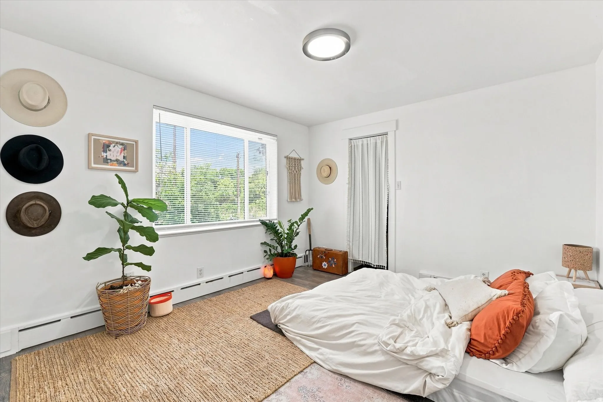 White painted walls with a single window and wood-finish flooring