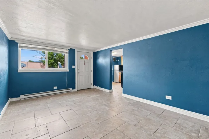Tile flooring with rectangular pattern, white trim, and a prominent window