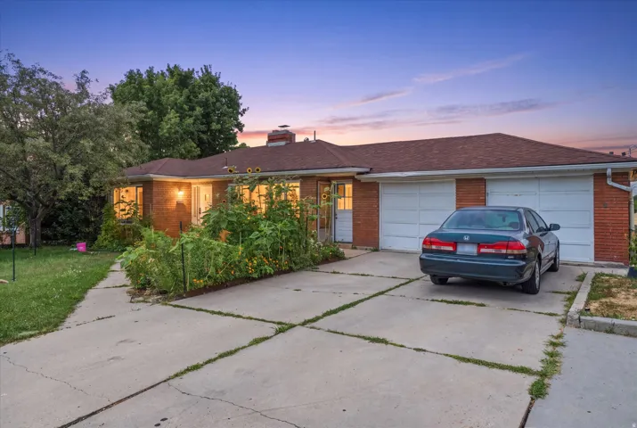 Brick exterior, pitched roof, attached two-car garage, and concrete driveway