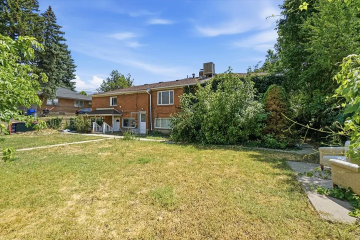 Brick exterior featuring multiple windows and a covered porch with white railings