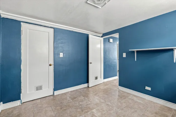 Tiled flooring, white trim, and crown molding
