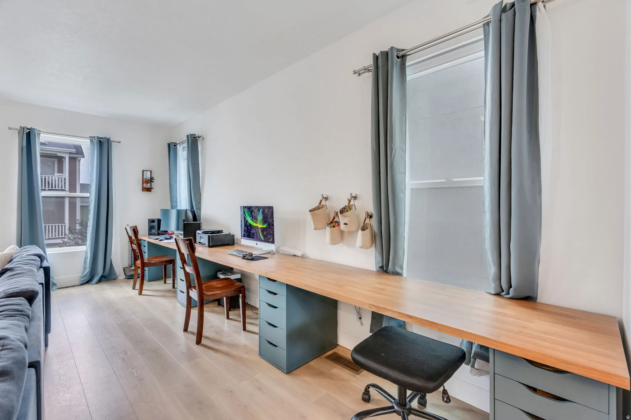 Light wood-finish flooring complements the white walls and multiple windows