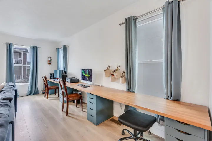 Light wood-finish flooring complements the white walls and multiple windows