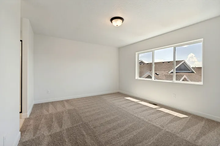 Bright interior space featuring neutral wall finishes and patterned carpeting