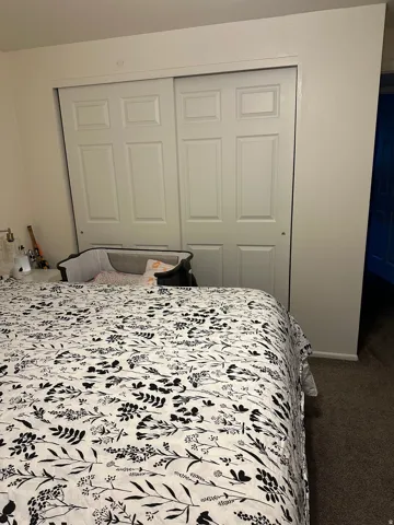 Bedroom featuring neutral wall paint, bi-fold closet doors, and carpet flooring