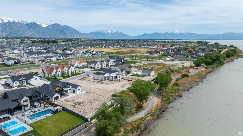 Aerial view showcasing a community situated beside a body of water with distant snow-capped mountains