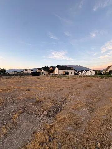 Open land parcel with visible mountain scenery, surrounded by existing residential structures