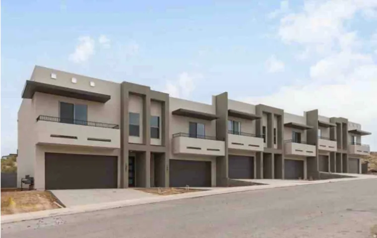 Contemporary multi-level exterior with stucco finish and prominent dark garage doors