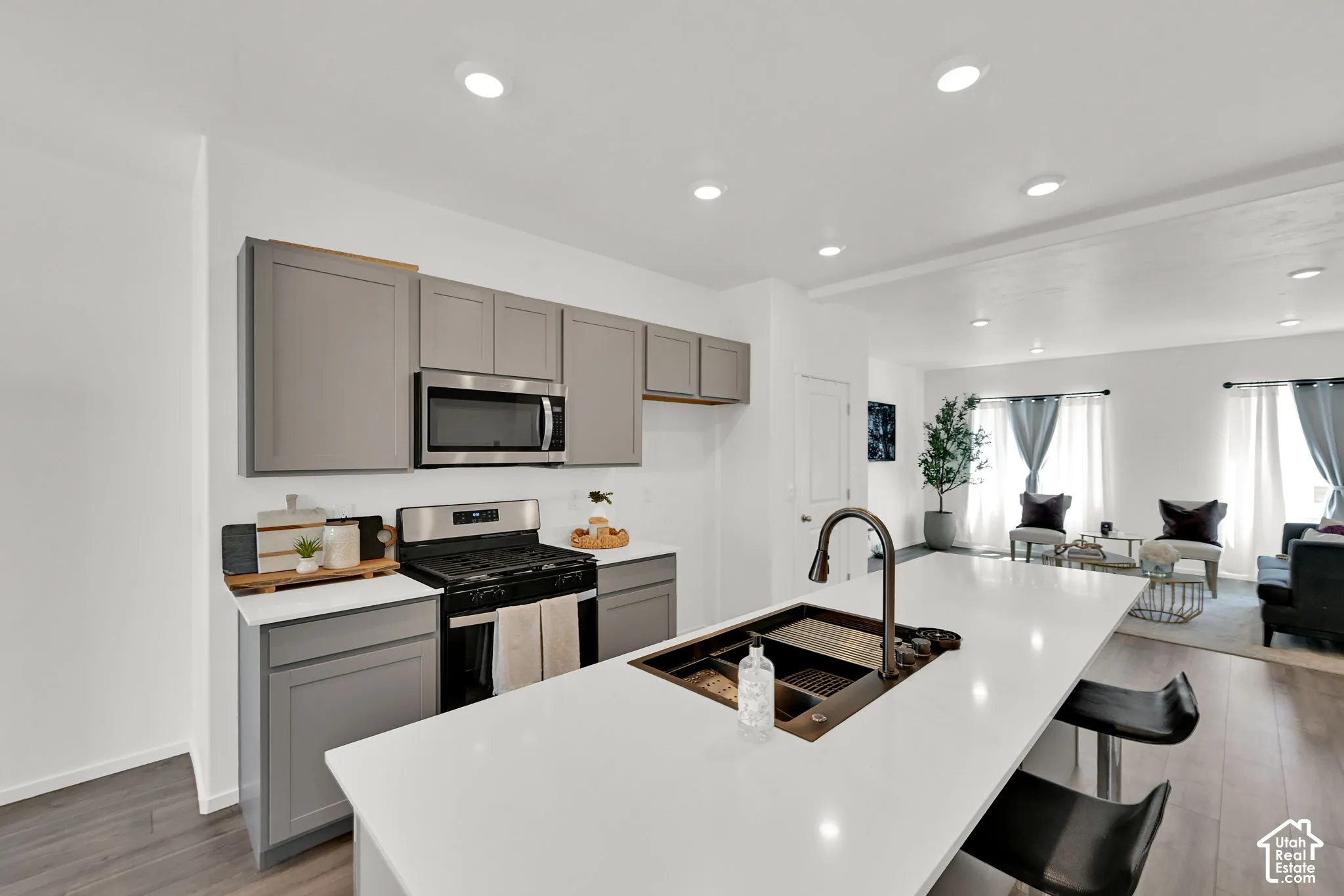 Modern kitchen featuring a large island with an undermount sink and a gooseneck faucet