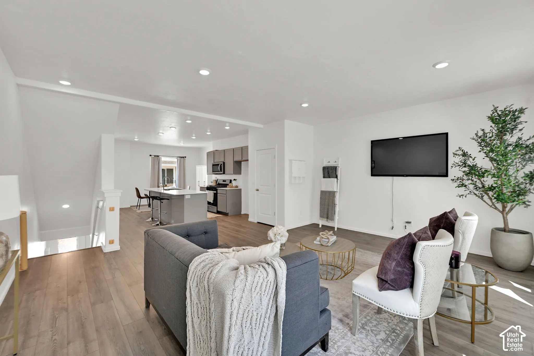 Open-concept living space featuring wood-finish flooring, recessed lighting, and a neutral color palette