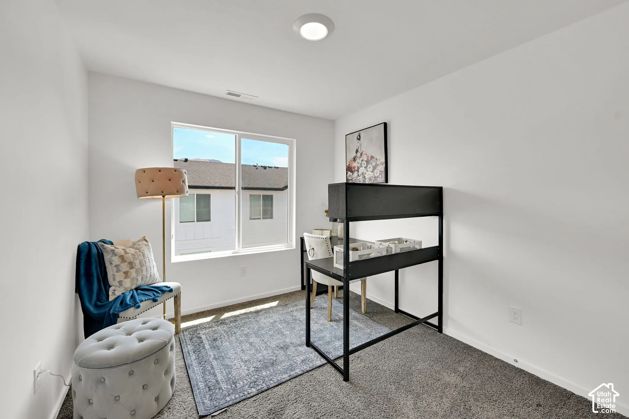 Carpeted room with a large window, white walls, and a recessed ceiling light