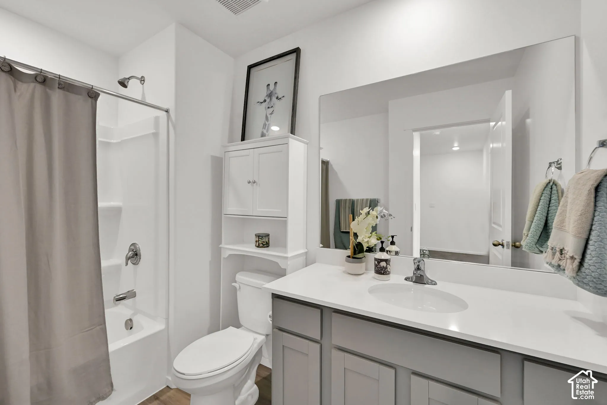 Bathroom featuring a single vanity with a white countertop and gray cabinetry