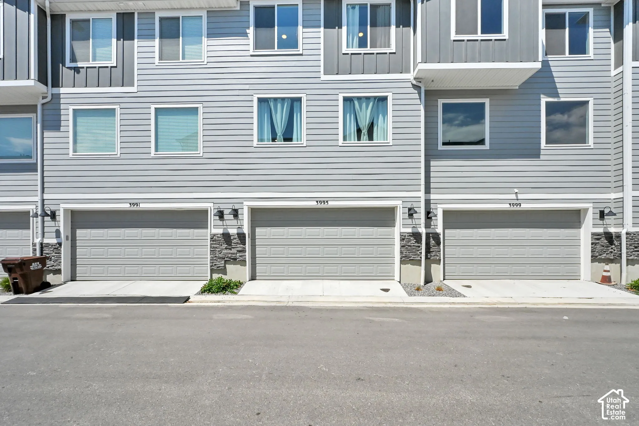 Contemporary townhouse exterior featuring light gray horizontal siding and dark gray vertical siding accents