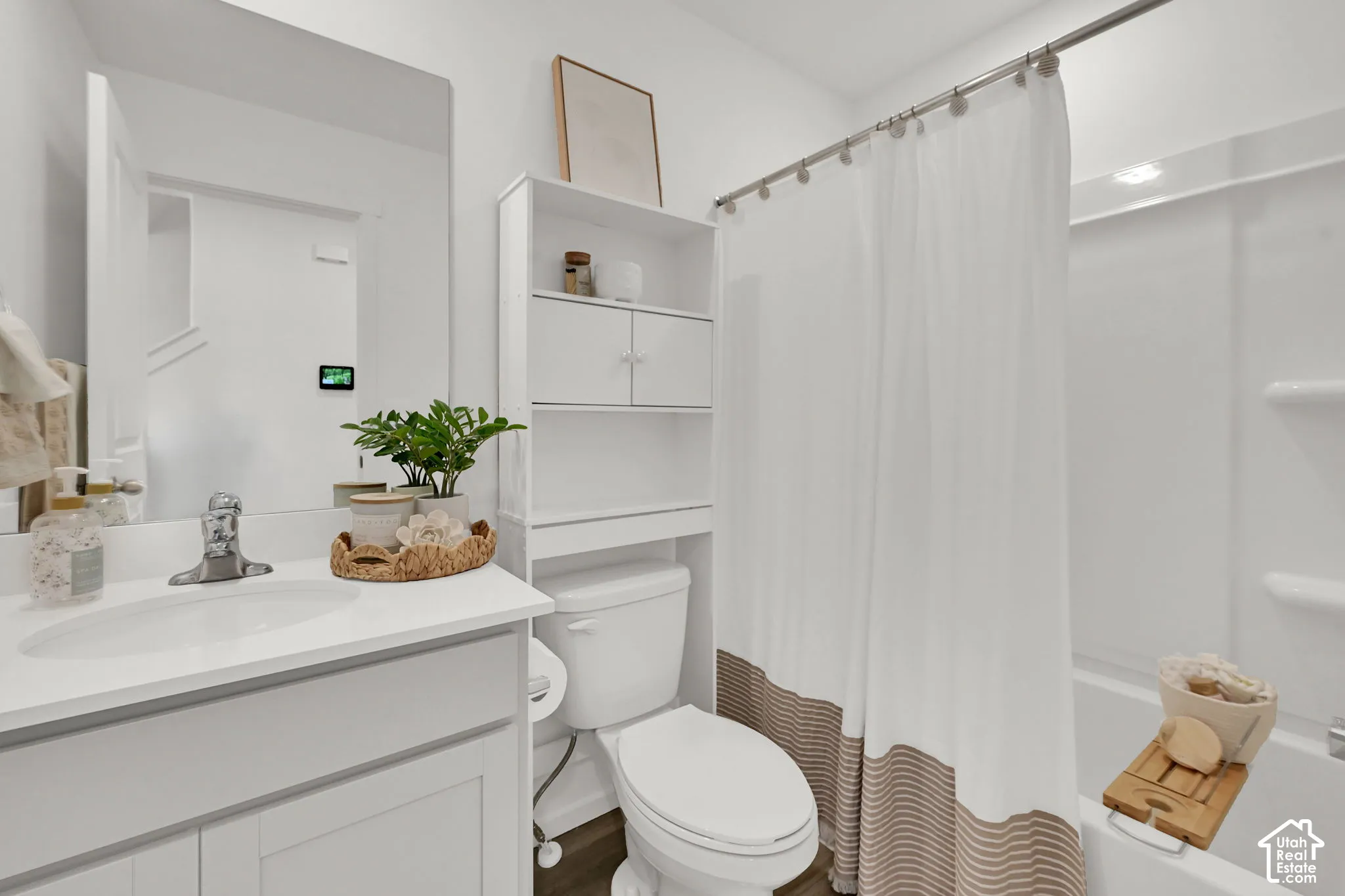 Bathroom featuring a white vanity with an integrated sink, polished chrome faucet, and a large wall mirror