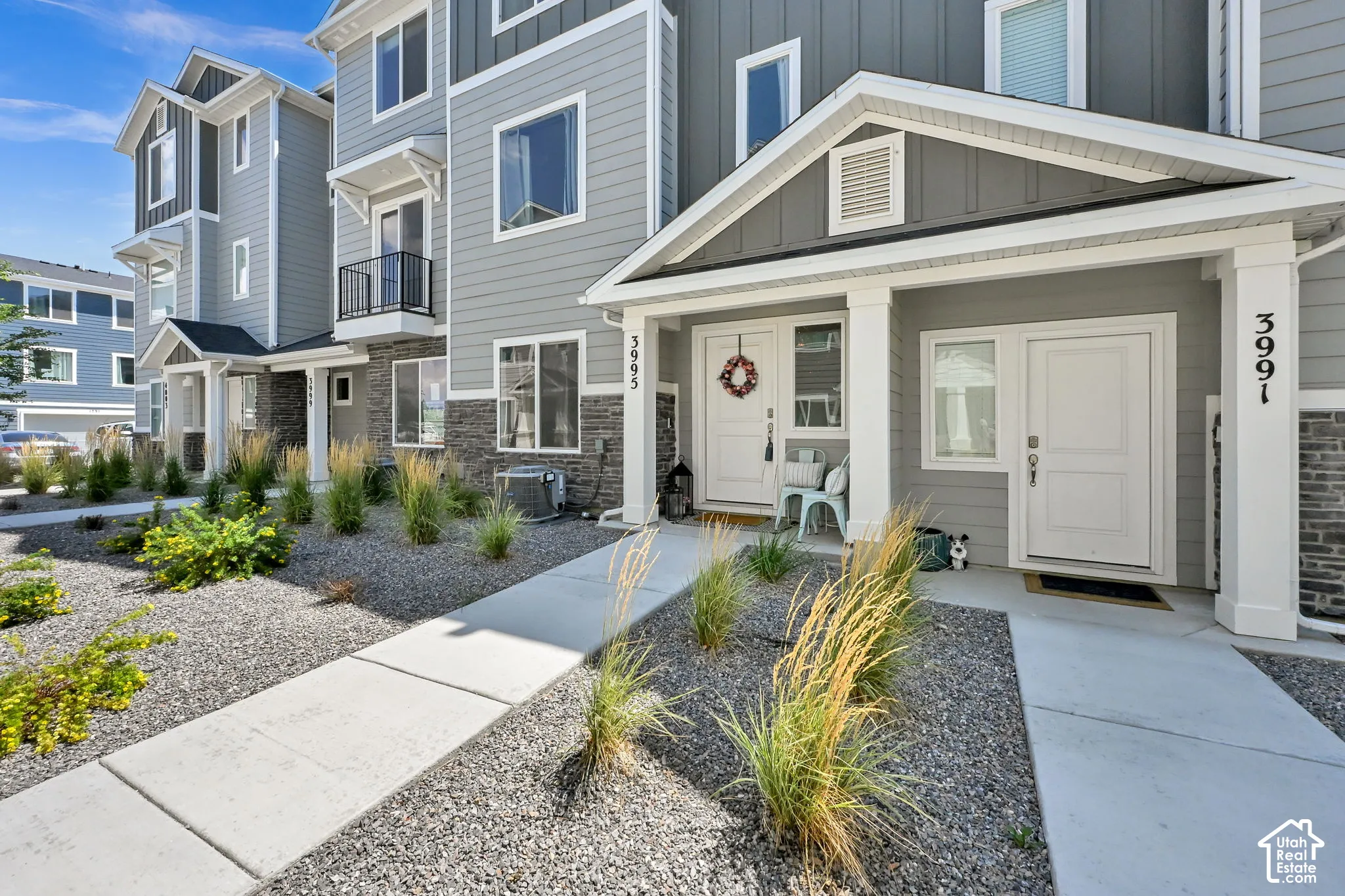 Modern townhome exterior featuring gray siding and stone accents