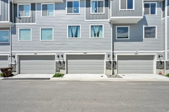 Contemporary townhouse exterior featuring light gray horizontal siding and dark gray vertical siding accents