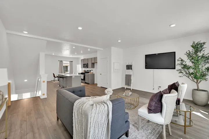 Open-concept living space featuring wood-finish flooring, recessed lighting, and a neutral color palette