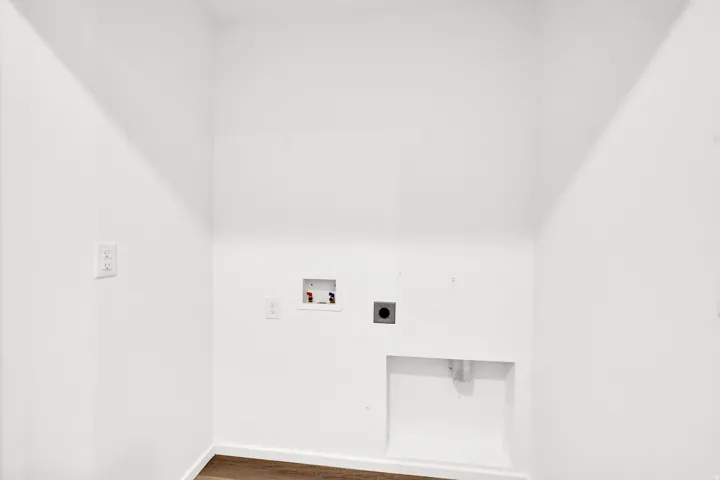Laundry area featuring white walls, wood-finish flooring, and utility hookups for washer and dryer
