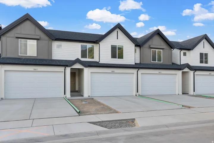 Contemporary townhome facade featuring a white horizontal siding and dark gray vertical accents