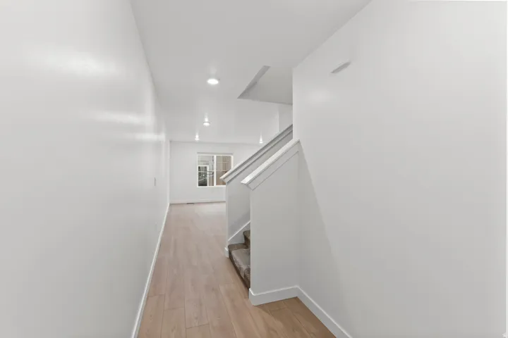 Foyer featuring light wood-finish flooring, white walls, recessed lighting, and a window
