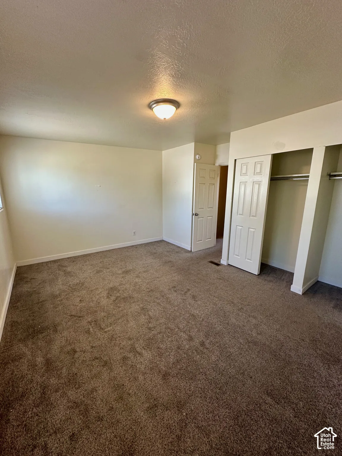 Spacious interior featuring brown carpeting and light-colored walls