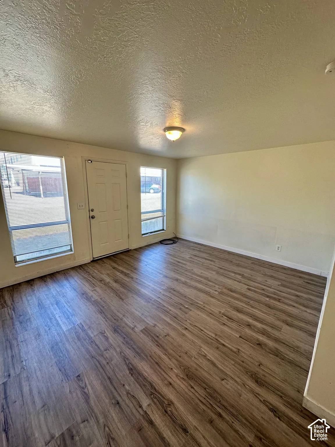 Open-concept room featuring wood-finish flooring, neutral wall tones, and recessed lighting