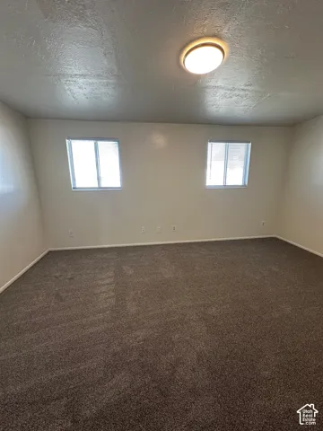 Spacious room with dark gray carpeting