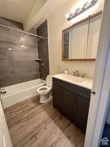 Bathroom featuring a dark gray vanity with a white countertop and undermount sink, framed mirror, and chrome vanity light fixture