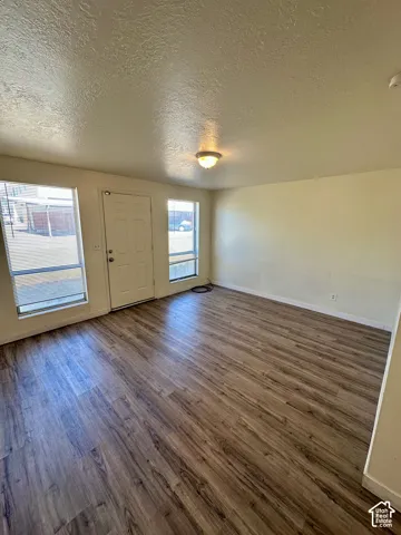 Open-concept room featuring wood-finish flooring, neutral wall tones, and recessed lighting